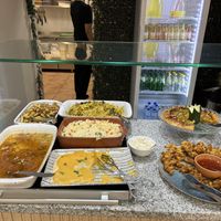 Hot food options inc pizza with lemonade in the fridge behind.  at Verde Hut in Porto