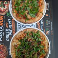 Bottom: pizza with eggplant, zucchini, rucola and olives 
Top: pizza with olives and rucola at PastaRun in Siracusa