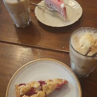 Iced latte (with vanilla ice), a raspberry cream cake and one with red berries and crumble on top at V-Cake Cafe in Dresden