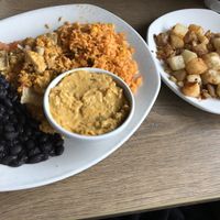 Home fries, vegan queso (so good!) and the main dish is tofu Migas which has tortilla chips mixed in, rice and black beans  at Kerbey Lane Cafe - Central in Austin