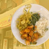 Vegan meal (plated at home) superposed over storefront at Punjabi Junction Of 87th in New York City