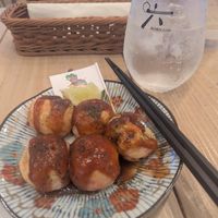 takoyaki 6 portion (i had already eaten 1 oops). I hadn't put mayonnaise on yet. 

Gin & Tonic pictured behind. The lime wedge was from the glass. at Pivot BASE Cafe & Bar ＠Dotonbori in Osaka