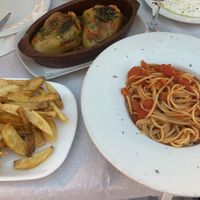 Fresh tomato pasta, stuffed peppers, and fried potatoes. Included bread basket not pictured  at Sofra Shkodrane in Shkoder
