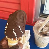 Oreo, cookie flurry, a.k.a. Oreo, cookie blizzard and vegan soft serve ice cream on a cone dipped in chocolate  at Dairy Twist Cafe in Wolverine Lake