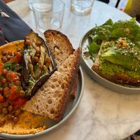 Aubergine and humous plate with crunchy chickpeas and avocado and pea purée toast. at Maison Fleuret in Paris