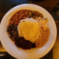 Middle plate contains 5-curry dish with papadam tent and rice in the middle. Two dishes of dahl on the outside plates at Curry Insel in Vienna
