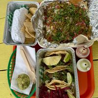Clockwise from Top Left: Burrito Jr (Seitan Carnitas), Impossible Nachos, and Taco Trio (Al Pastor, Seitan Carnitas, Capeado)  at Taqueria Vegana  in Toronto