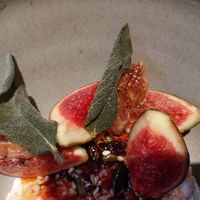 sliced fig (beautifully ripe) with crispy sage on a bed of something... at Holy Carrot in West London