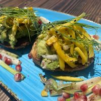 Avocado bagels topped with fresh mango and charred corn  at Nalu Vida - Venice Beach in Los Angeles