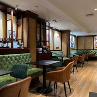 Interior dining area with plush green benches at Bitter in Tirana