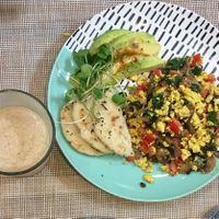 Scrambled tofu with tomatoes, mushrooms, spinach, avocado & corn bread. at Raw Cafe in Lima
