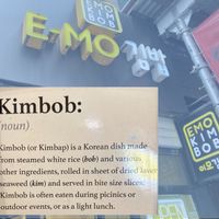 Wall description, superposed over front of shop at E-MO in New York City