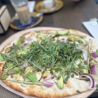 Avocado and asaparagus flammkuchen (€12,99) and oat latte macchiato (€5,25).  at Werelds in de Tuin Tiel in Kapel Avezaath