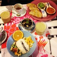 Delicious breakfast of homemade yoghurt with lots of fruit and chia seeds, avocado and tomato toast and fresh pressed kiwi juice at Rayen Vegano in Madrid
