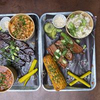 Rib and brisket trays with Mac and cheese, baked beans, corn on cob and potato salad.   at Saint Monday in East London