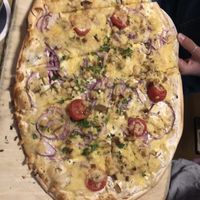 Flammkuchen (typical dish from the region) with plant based cheese, onions, tomatoes and tofu  at Schwarzer Kater in Freiburg