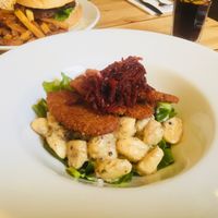 Schnitzel on top of creamy gnocchi and fresh greens at Mono in Glasgow