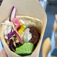 Falafel wrap with fresh made flatbread, herby falafel, tahini, coconut yogurt, pickled onions and loads of herbs.  at Ibiza in Santa Cruz