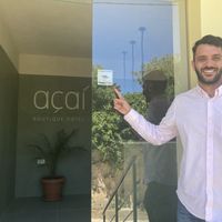 Yannis, hotel owner,  proudly showing Happycow sticker  at Acai Plant Based Hotel & Restaurant in Rhodes