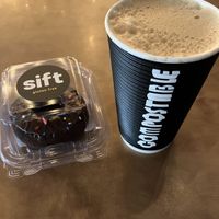 Coffee with oat milk (compostable cup) and a vegan chocolate donut from Sift. at BlueNose Coffee in Farmington