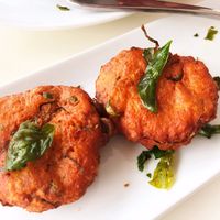 Tod Munn: Thai Un-fish cake, chickpeas, green beans, kefir lime leaves, curry paste, crispy basil with cucumber peanuts relish at Satdha Plant Based Thai Kitchen in Santa Monica