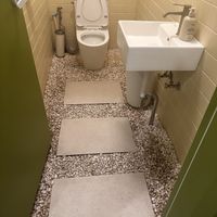 The toilet has little pebbles  at URT 유알티 in Seoul