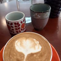 Cappuccino with oat milk and free water at Dream Beans Coffee Roastery in Hanoi