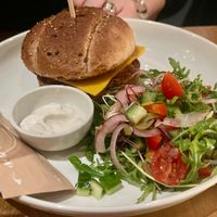 Hoofdgerecht: Oesterzwamburger in een meergranenbroodje met gegrilde groenten, augurk, tzatziki en een seizoensslaatje, aardappelwedges, met een dragon-veganaise € 23 (dec.2025) at Kosmopoliet in Bruges