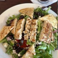 mediterranean salad with vegan chicken and feta, not featuring cut-off iced coffee and fried tofu sandwich served with cabbage slaw, seasoned fries, and a side of vegan ranch at Earth Bistro in Cleveland
