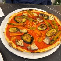 Vegana Pizza with a selection of grilled aubergine/eggplant, zucchini and peppers/capsicum on a tomato sauce base with Roman style thin crust at Alla Bracioleria Vaticano in Rome