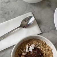 Almond milk porridge with cinnamon stewed apple and crumble   at Grind - Shoreditch in London