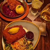Crispy steak with potato, cabbage, apple & beer gravy (top) and Vienna style schnitzel with potato salad and lingonberry jam. at Bodhi in Munich