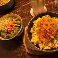 My cheesy dish with onion rings atop and the side salad. at Bodhi in Munich