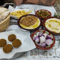 Hummus with foul, grilled eggplants, onions, olives, falafel, fries and bread at Beirut Restaurant in Doha