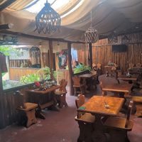 Outdoor seating around a garden with a fig tree at La Cazuela in Cuenca