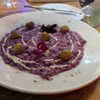 Risotto al cavolo cappuccio viola: Eye Catching purple risotto rice made with purple cabb served with parmesan fondue and pan-fried sausage at Sora Diana in Edinburgh