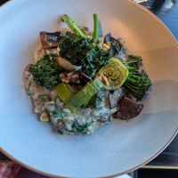 Field and porcini mushroom risotto, charred broccolini, Szechuan roasted walnuts and crispy kale finished with white truffle oil and vegan cheese at Panorama Room in Mt Cook