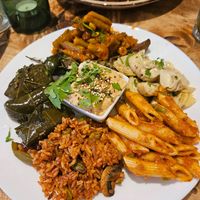 Antipasti: gefüllte Weinblätter,  Mediterraner Reis mit Oliven, Rote Pesto Pasta, Artischockenherzen, Geschmorte grüne Bohnen,gegrillte Zucchini mit Thymian; in der Mitte: Hummu at Vengo Die Gemusekuche in Bremen