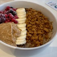 Porridge with banana, frozen berries, peanut butter, and crumbled biscoff  at blend in Newquay