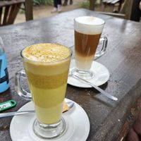 Turmeric Latte with almond milk and another latte with oat milk from the shop nearby. The share the same garden. at Jammwich  in Wilderness