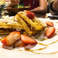 Vegan waffles with coconut flakes drizzle and strawberries at Well Dressed Salad Bar and Cafe in Central Singapore