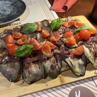 pinsa vegana topped with eggplants, cherry tomatoes, caramelized onions, and basil   at "DOC" EnoBistrot  in Rome