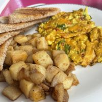 Scrambled tofu with cheese, tomato & onion served with soft melt in your mouth peppered potatoes   at Mamalicious in Hamburg