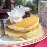Heavenly fluffy pancakes with blueberry compote between layers, whipped cream & maple syrup  at Mamalicious in Hamburg