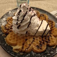 Vegan gluten free waffle with chocolate sauce, whipped cream and ice cream. at Kuparitalon Vohvelikahvila in Tampere