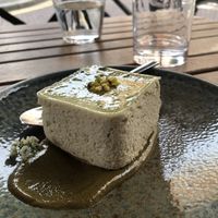 The cheesecake sitting in a pistachio sauce  at Kin Restaurant in London