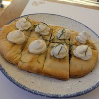 Pita with spinach inside and creamy blobs on top at GNOU in Athens