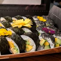 Close-up of Sushi arranged with flowers. The Sushi contains Mango, Avocado, cucmber. On the left are the 555 Veggie, on the right peace boy rolls. at BBQ SUSHI MOMO in Gossau