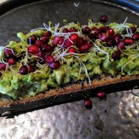 Zuurdesembroodje met avocado, alfalfa en granaatappelpitjes at Trankilo in Heemstede