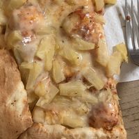 Half-eaten pineapple pizza with vegan cheese   at Woodstock's Pizza in San Luis Obispo